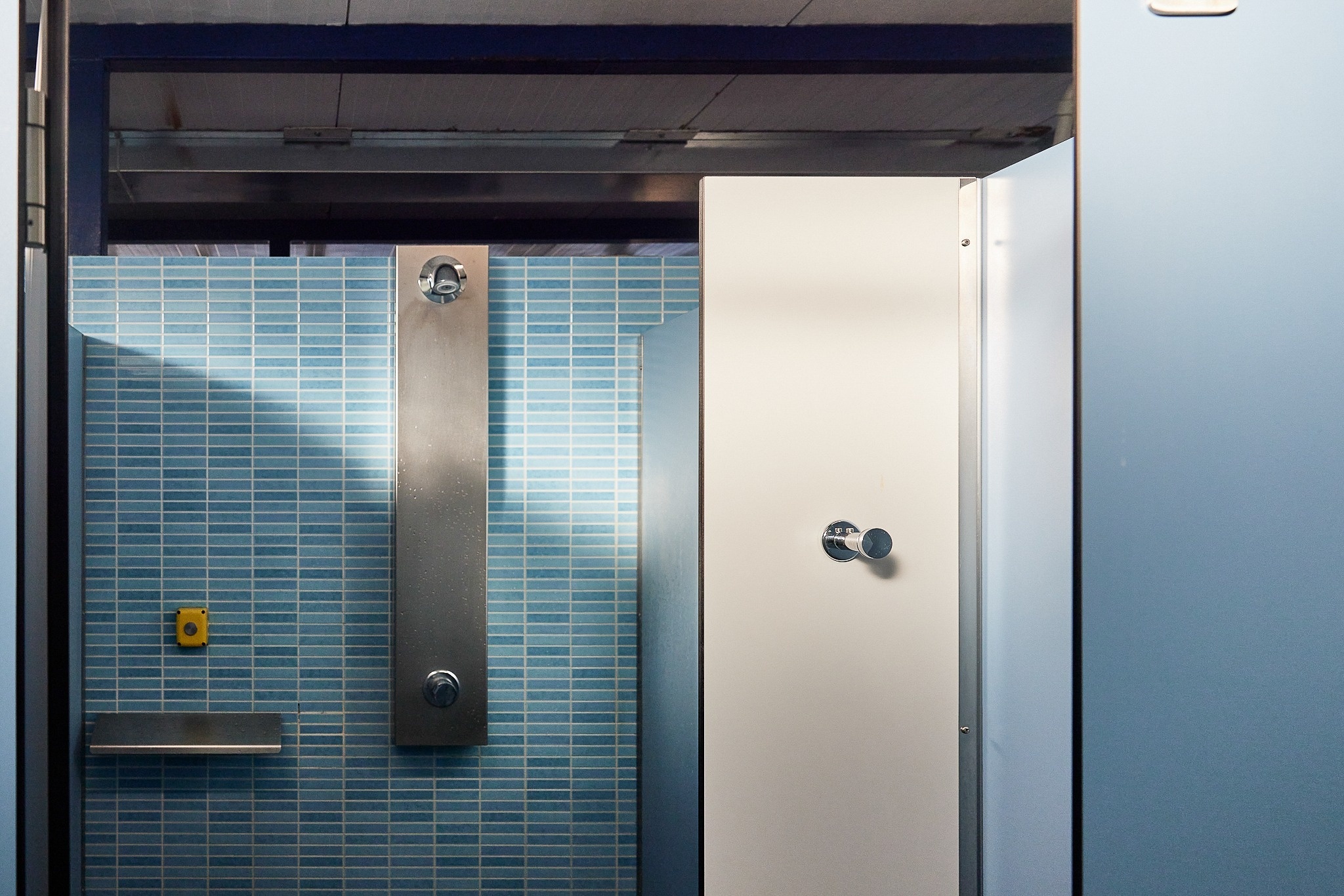 een badkamer met blauwe tegels en een douche