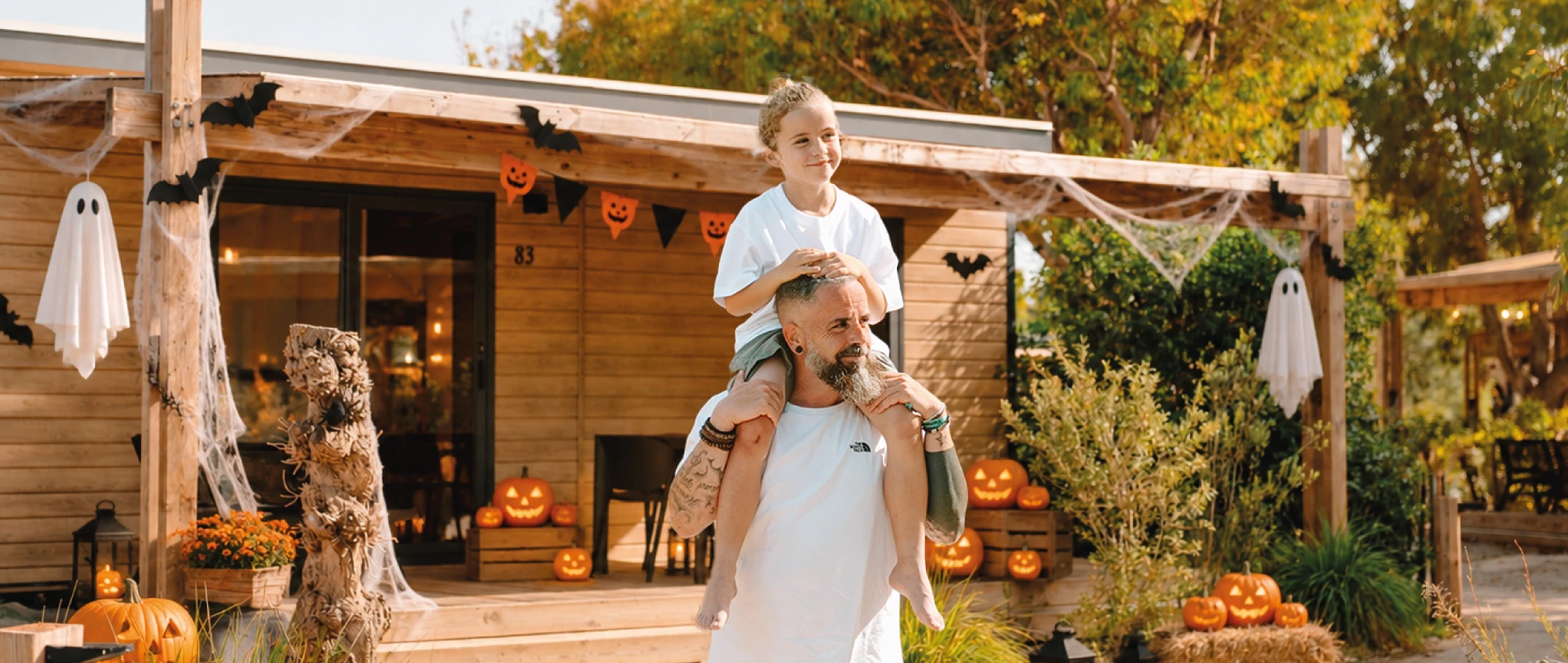 Familia disfrazada para Halloween en una cabaña acogedora con decoración espeluznante. Halloween | TAIGA | Campings & Resorts | Web Oficial