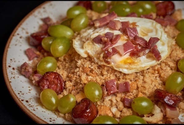 un gros plan d' une assiette de nourriture avec des raisins et des œufs