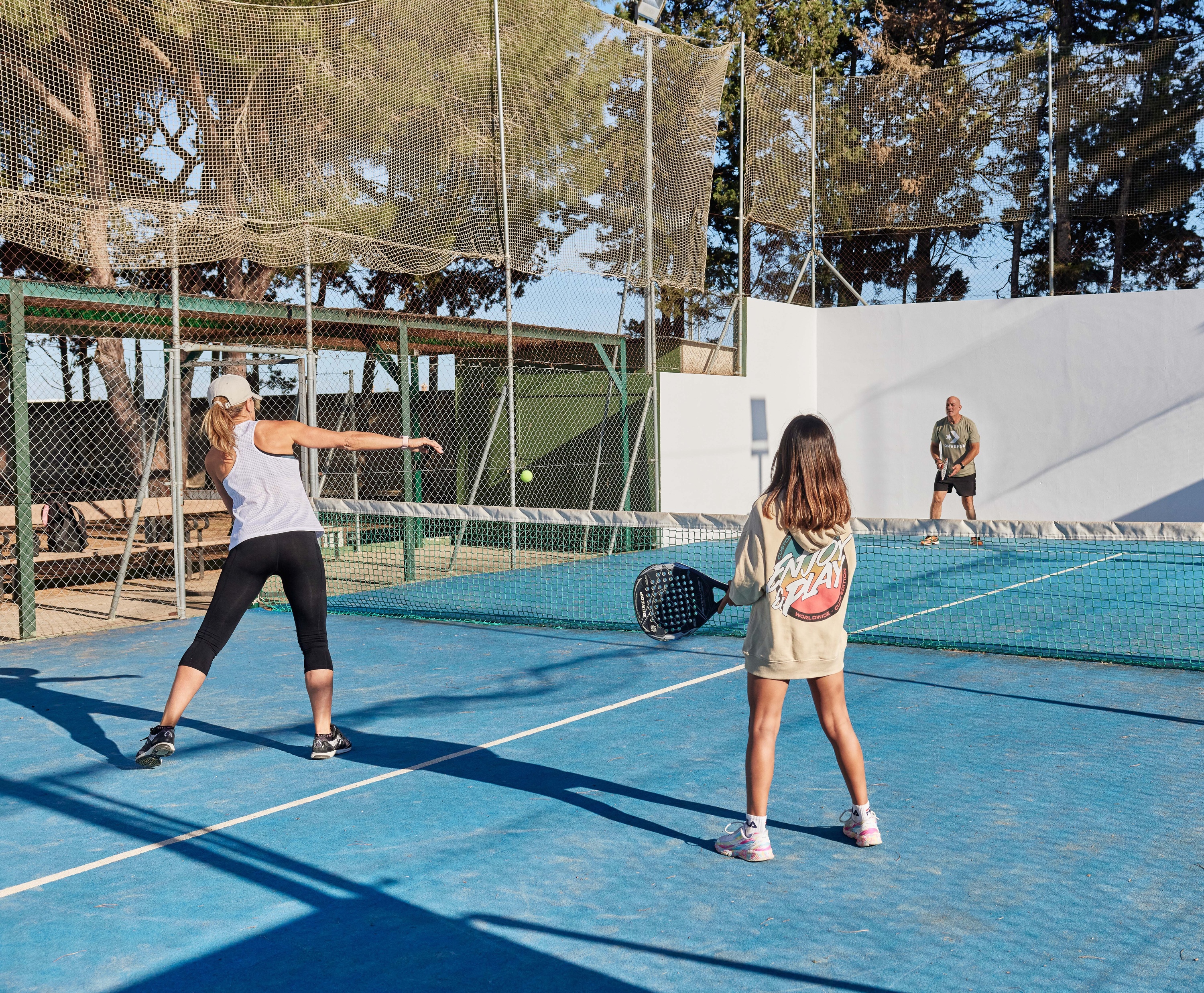 Raqueta y pelota de pádel en cancha azul, ideal para Taiga: Corporativa.
