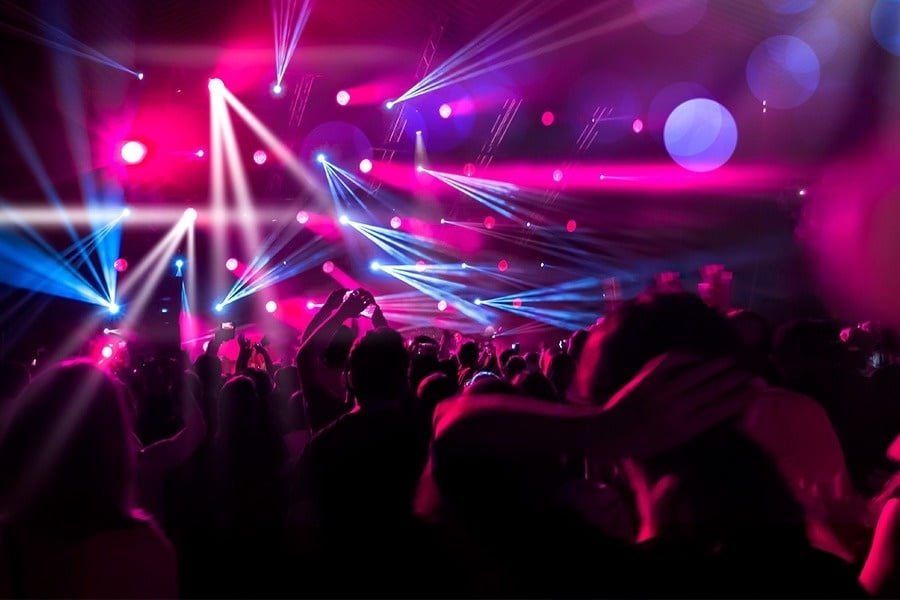 een menigte mensen houdt hun handen in de lucht bij een concert