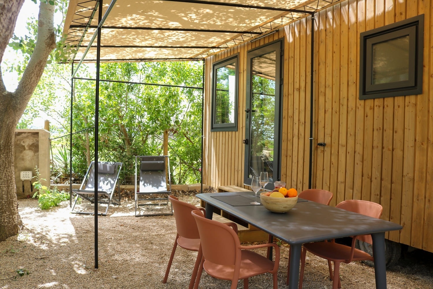 a wooden house with a table and chairs in front of it