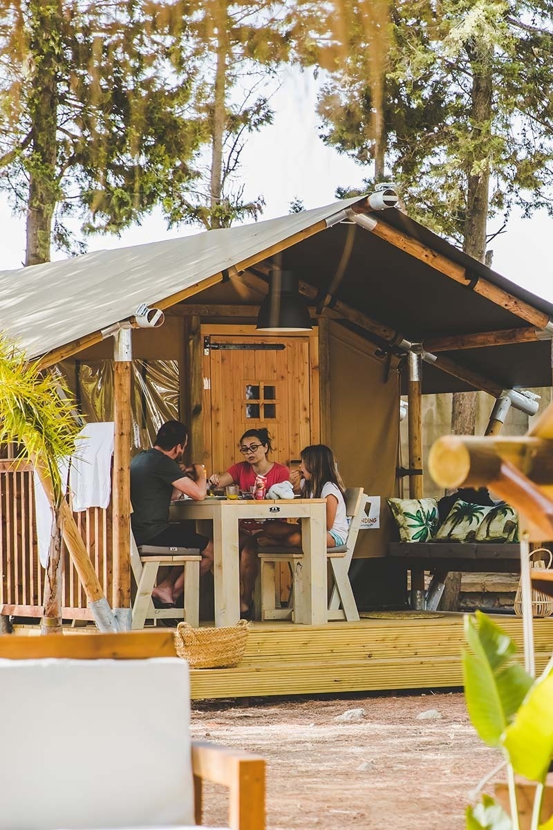 una família està senta a una mesa a l' aire lliure