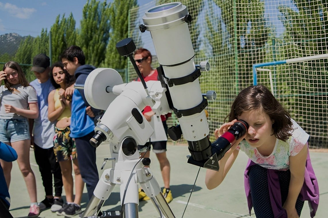 two little girls are running in the grass holding hands