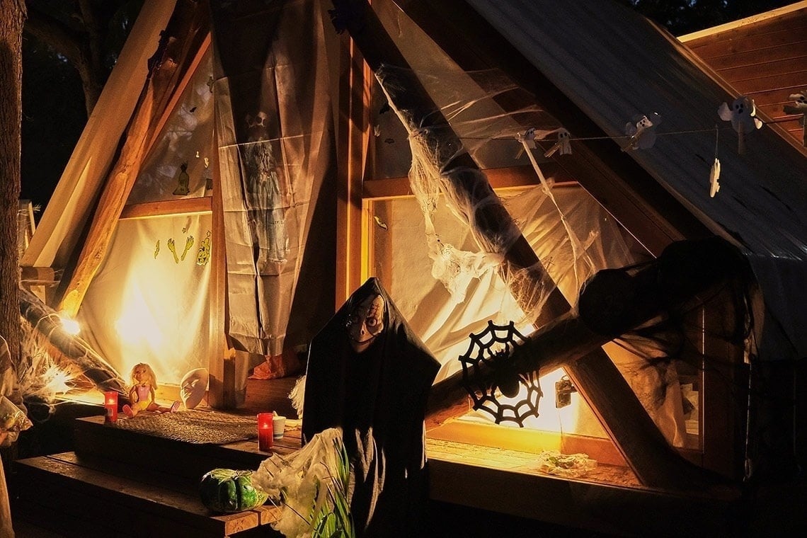 een spook staat voor een huis versierd voor halloween