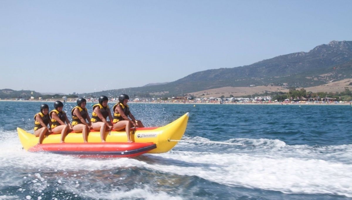 waves crashing on a rocky shoreline with a tower in the distance