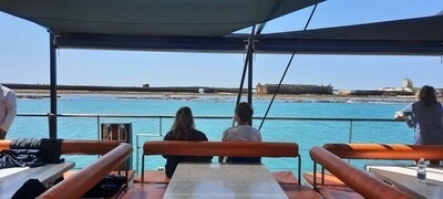 un hombre y una mujer están sentados en un barco mirando el océano .