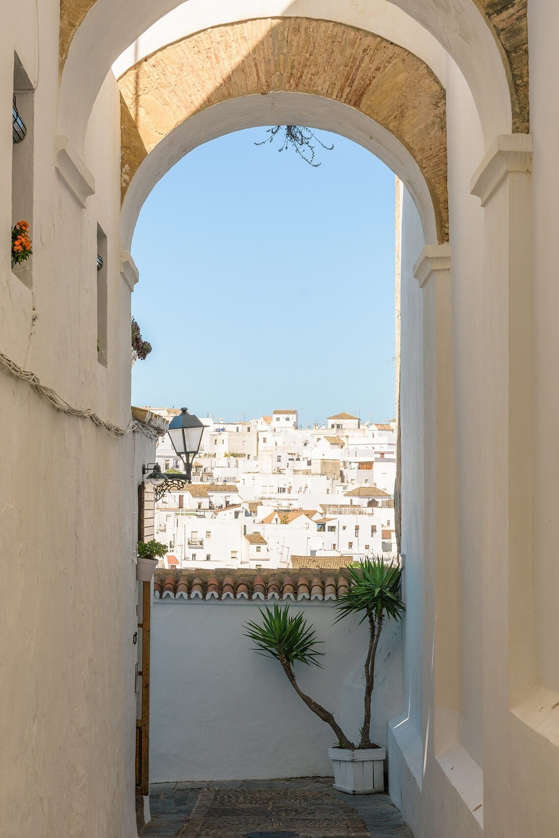 una vista de una ciudad blanca a través de un arco
