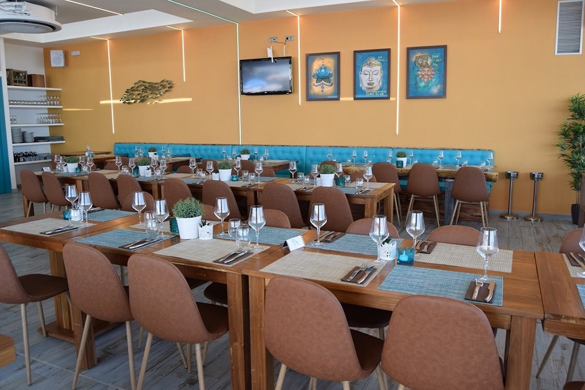 a dining room with tables and chairs and a tv on the wall
