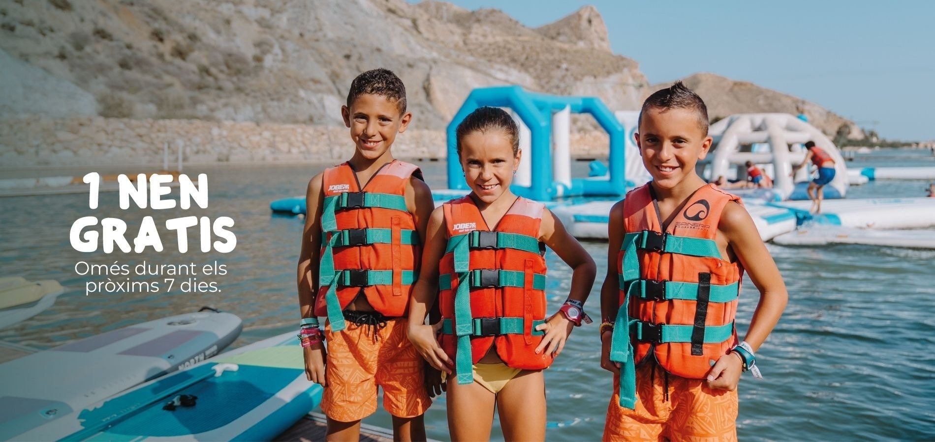 1 nen gratis! Nens contents amb armilles salvavides al parc aquàtic inflable. Estada familiar.