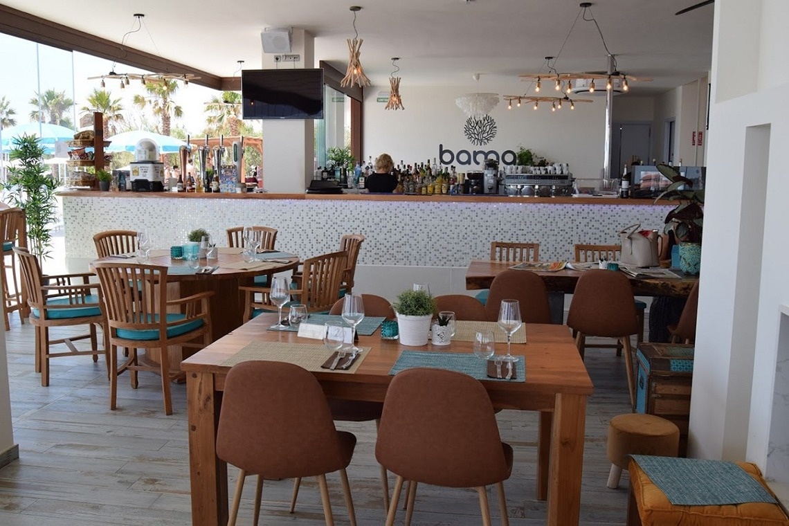 un restaurante lleno de mesas y sillas con la palabra barra en la pared