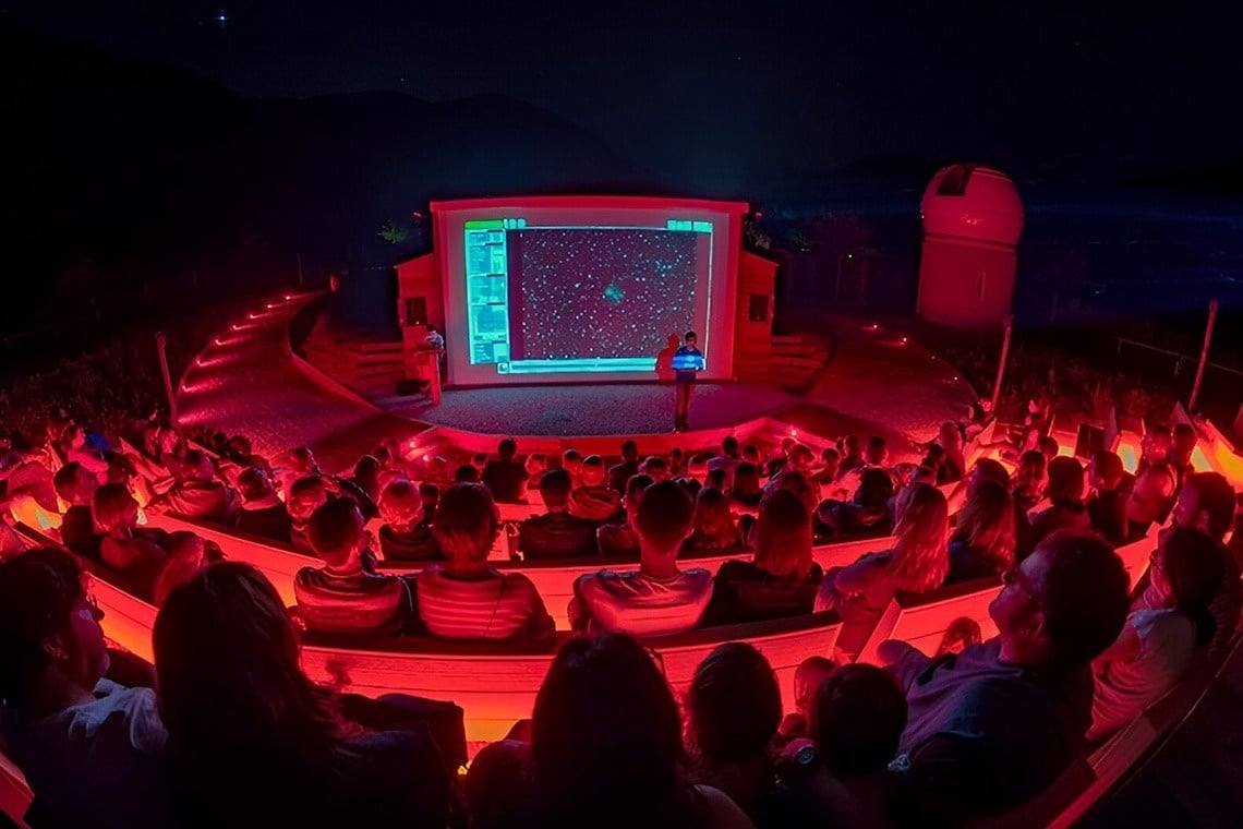 two little girls are running in the grass holding hands
