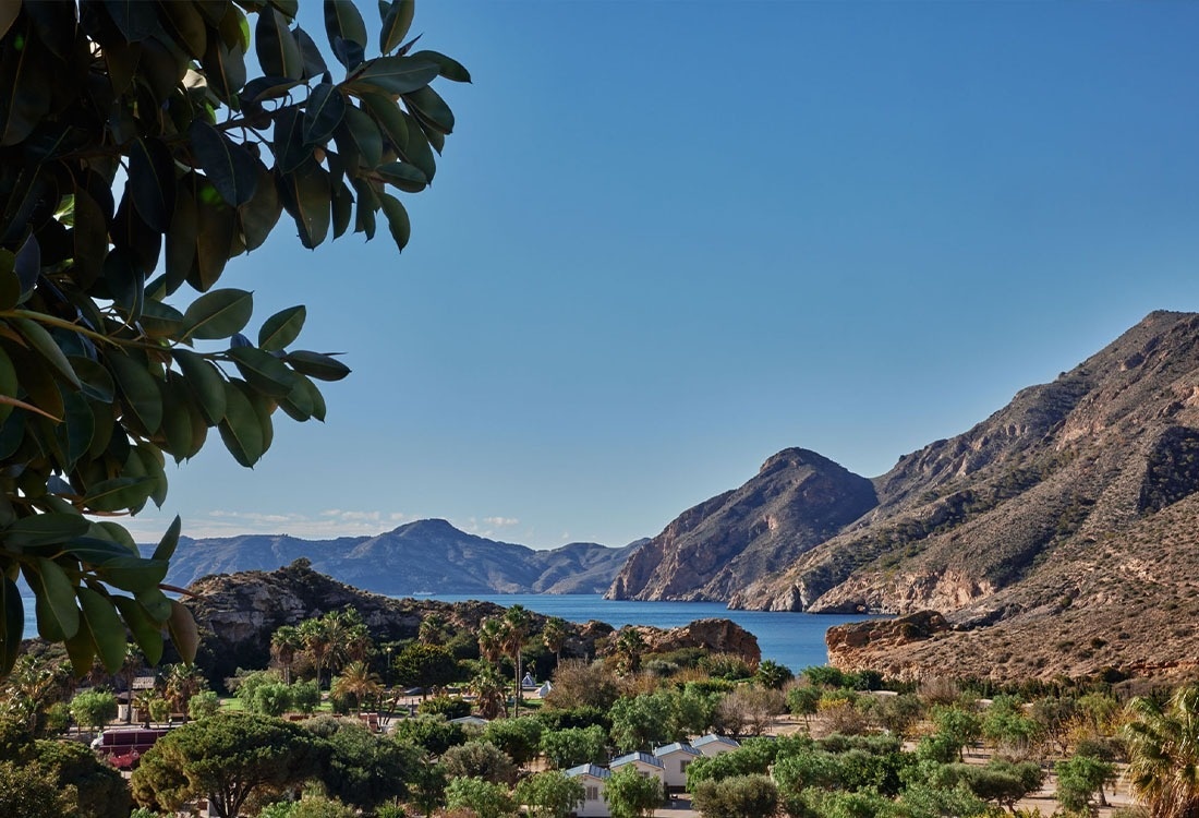 une route serpente autour d' un lac entouré de montagnes