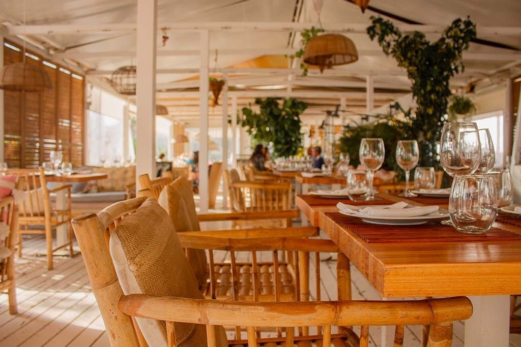 une salle à manger avec des tables en bois et des chaises en bambou