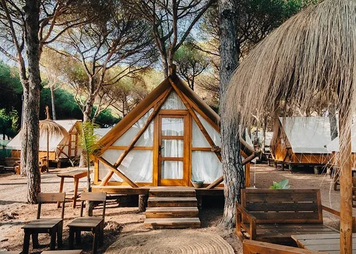 Glamping-Zelte mit Holzveranda und Gartenmöbeln im Pinienwald – ein Urlaubserlebnis mit TAIGA Conil | TAIGA | Campingplätze und Resorts in Spanien