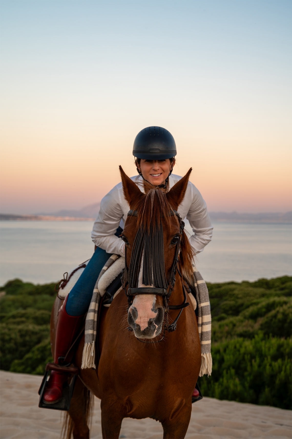 una persona a cavall amb el mar al fons