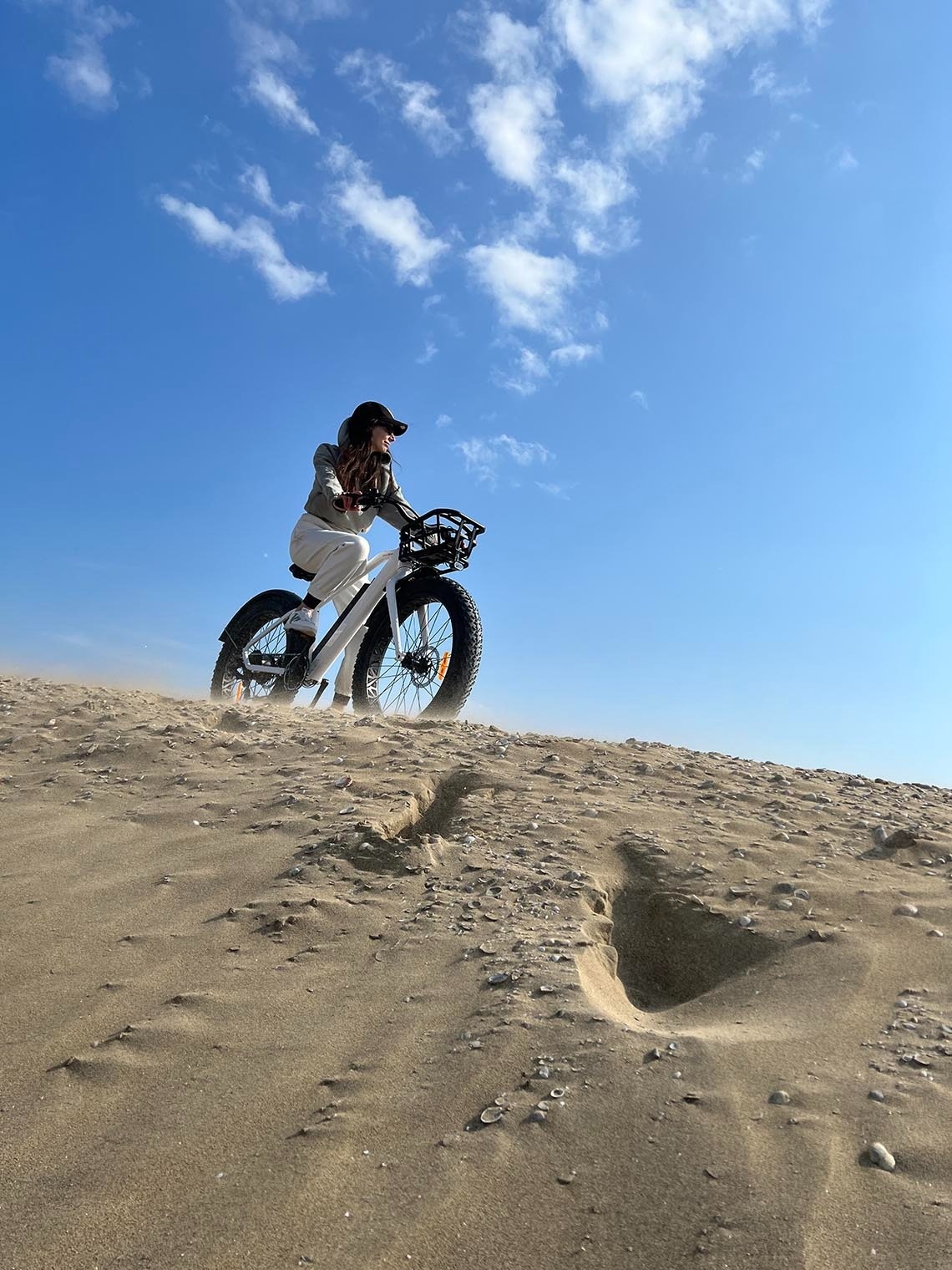 una persona s'envolta en una bicicleta blanca a través d' un desert