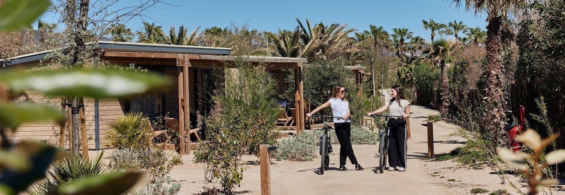 deux femmes se tiennent l' une à côté de l' autre tenant des vélos