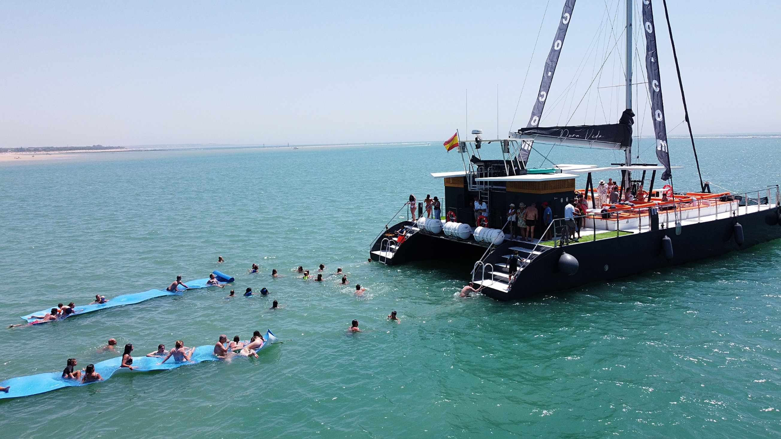 Enjoy a Taiga: Corporativa getaway: people swimming and relaxing on a catamaran.