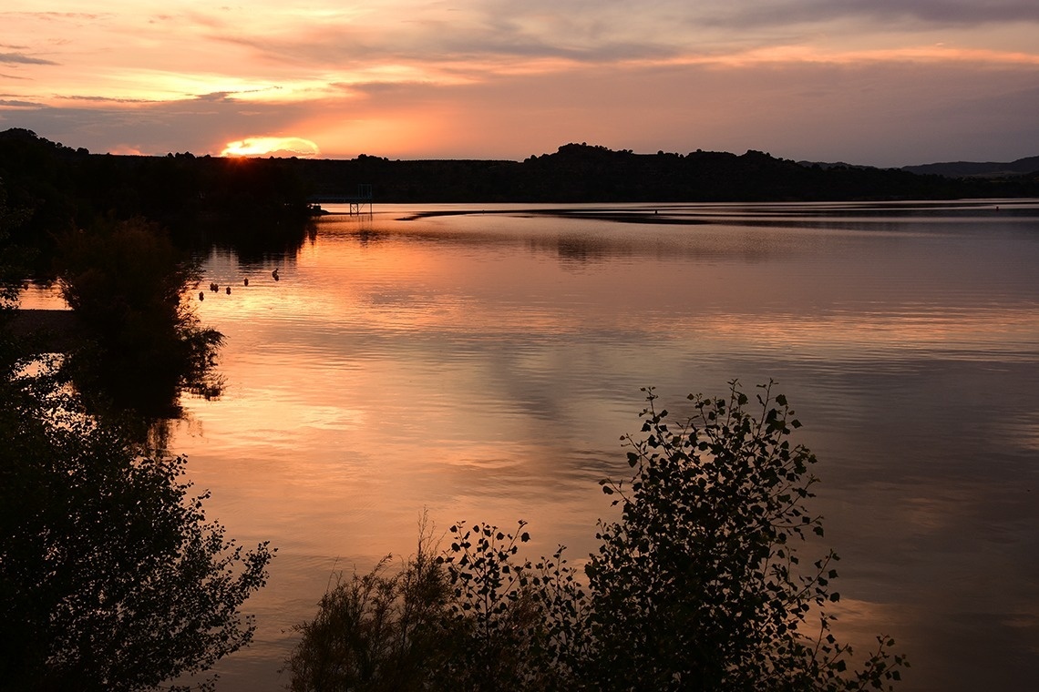 el sol s'acosta al fons d' un llac
