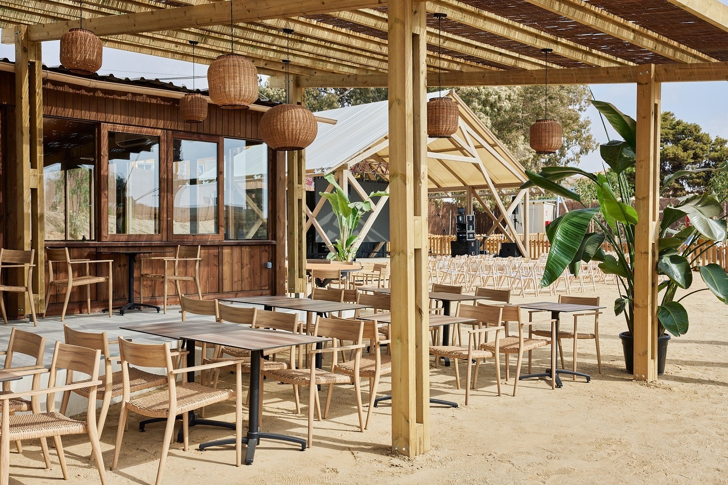 a wooden structure with tables and chairs in front of it