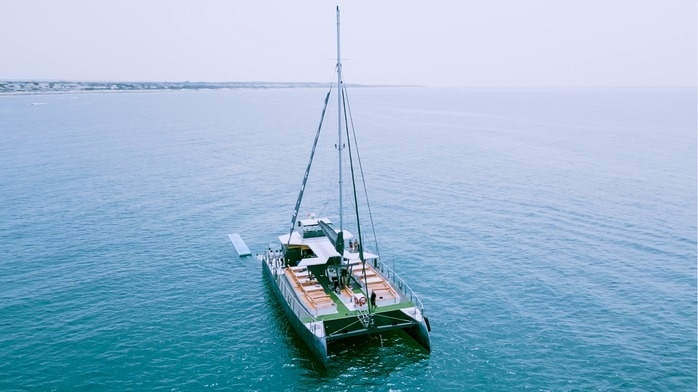 un velero está flotando en el océano y tiene una cubierta verde