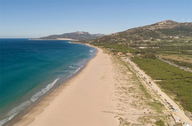 una vista aérea de una playa con montañas en el fondo