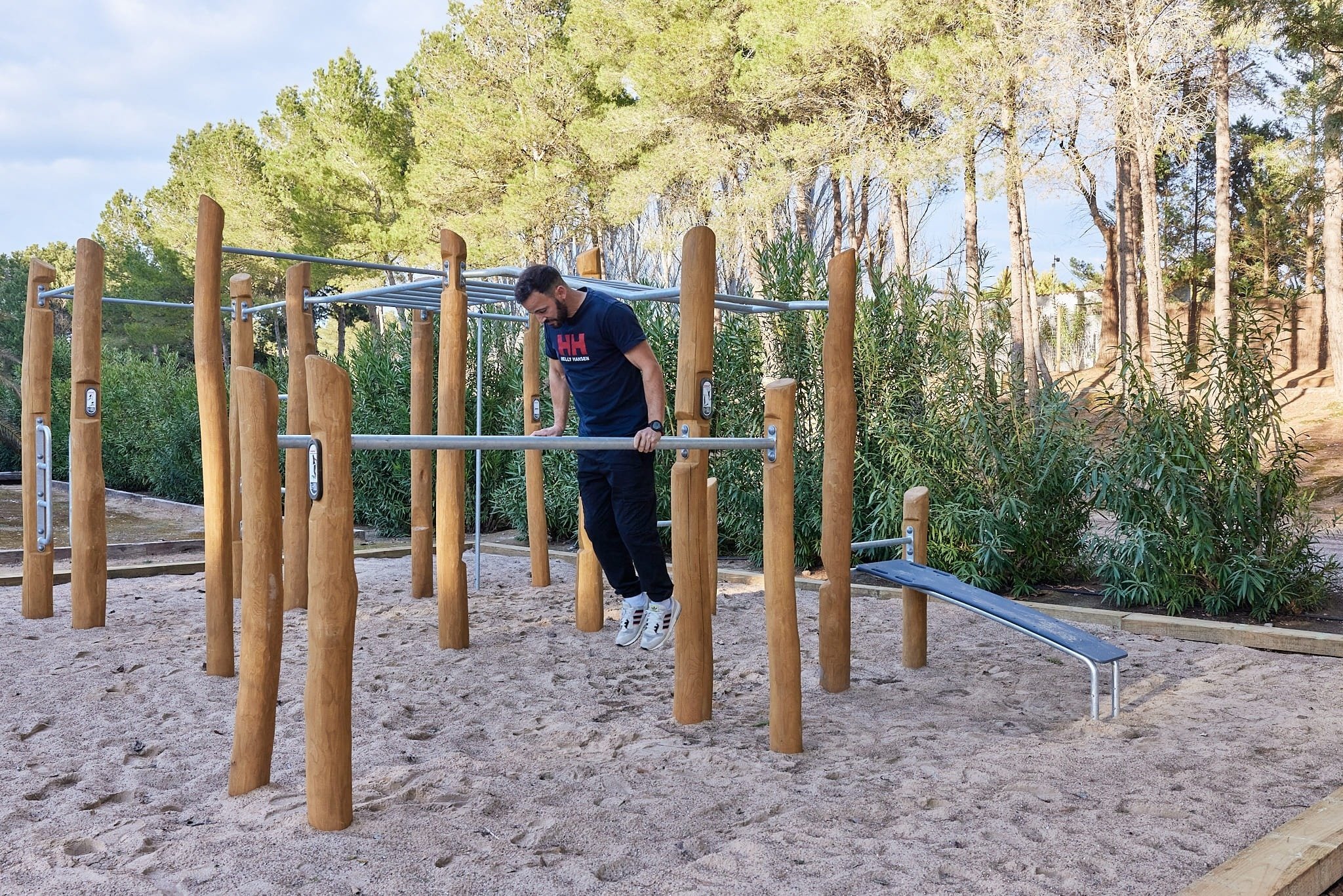 un hombre haciendo ejercicios en un parque con una camiseta que dice hh