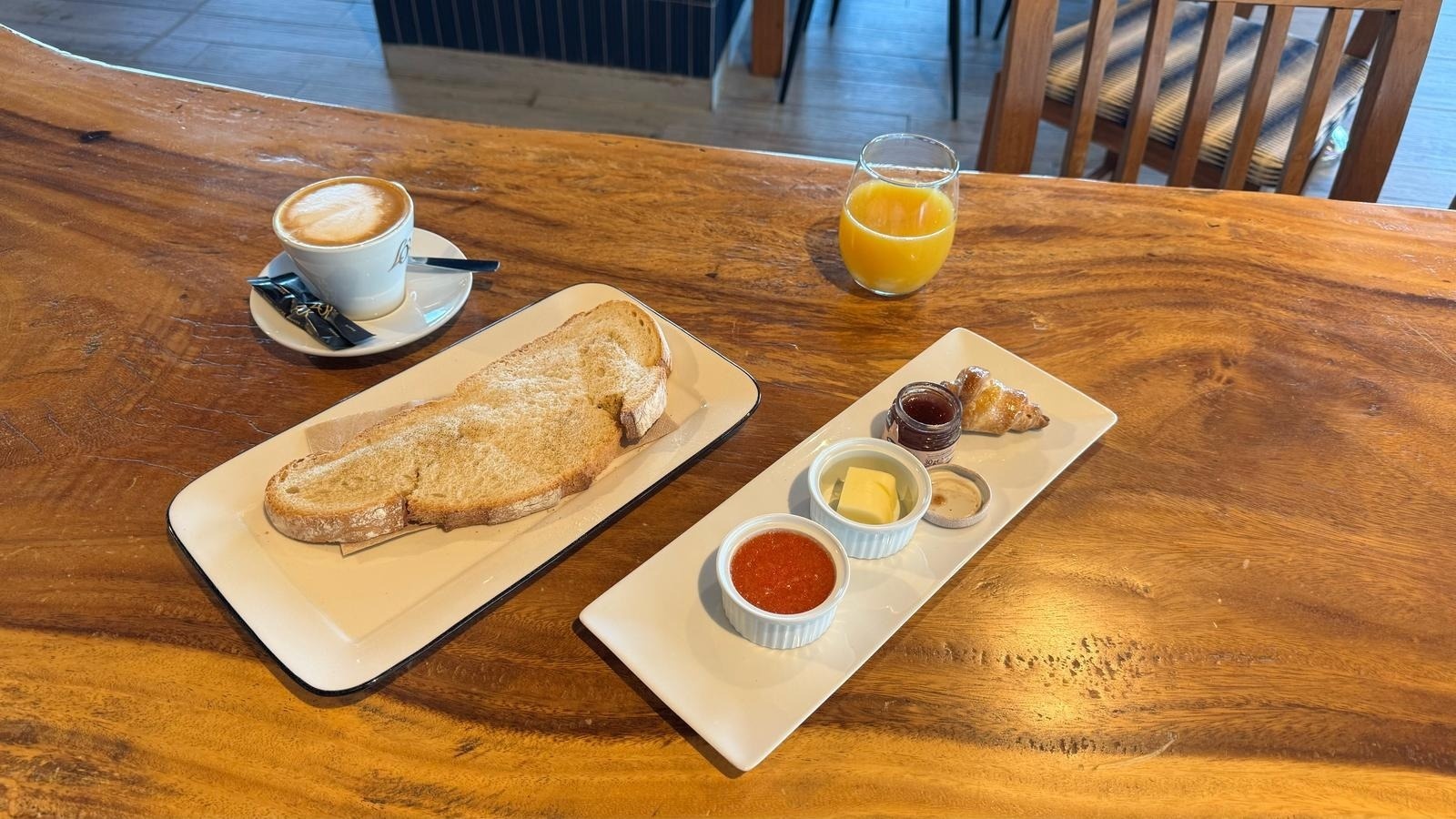 una mesa de madera con platos de comida y una taza de café