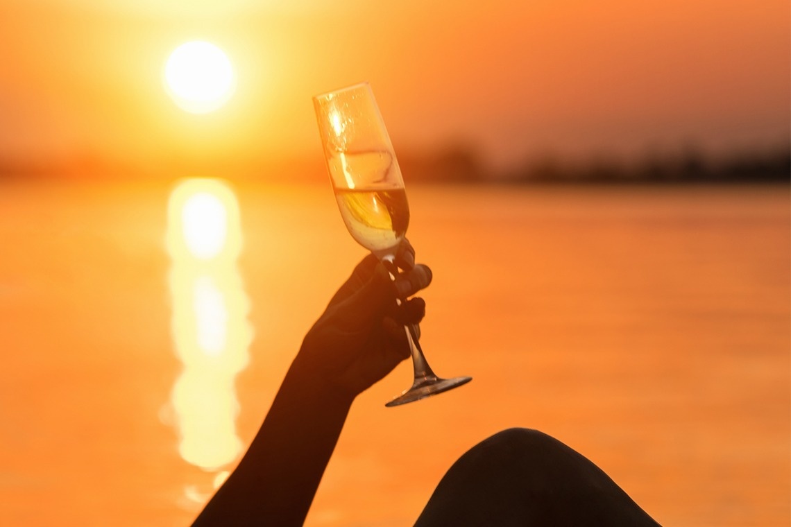 a man standing on a wooden dock holding a rope with oysters hanging from it