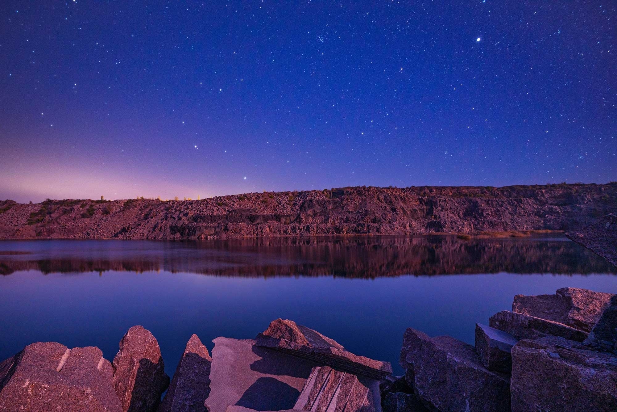 un lago con un cielo estrellado en el fondo