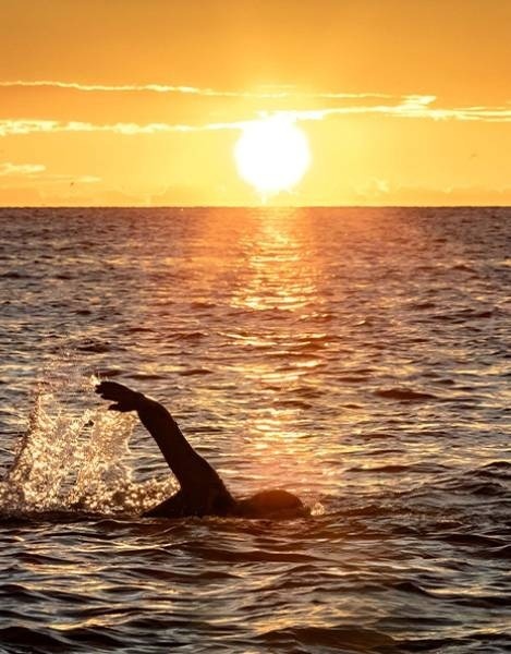 a person riding a surfboard in the water with a wing that says ' daiwa ' on it