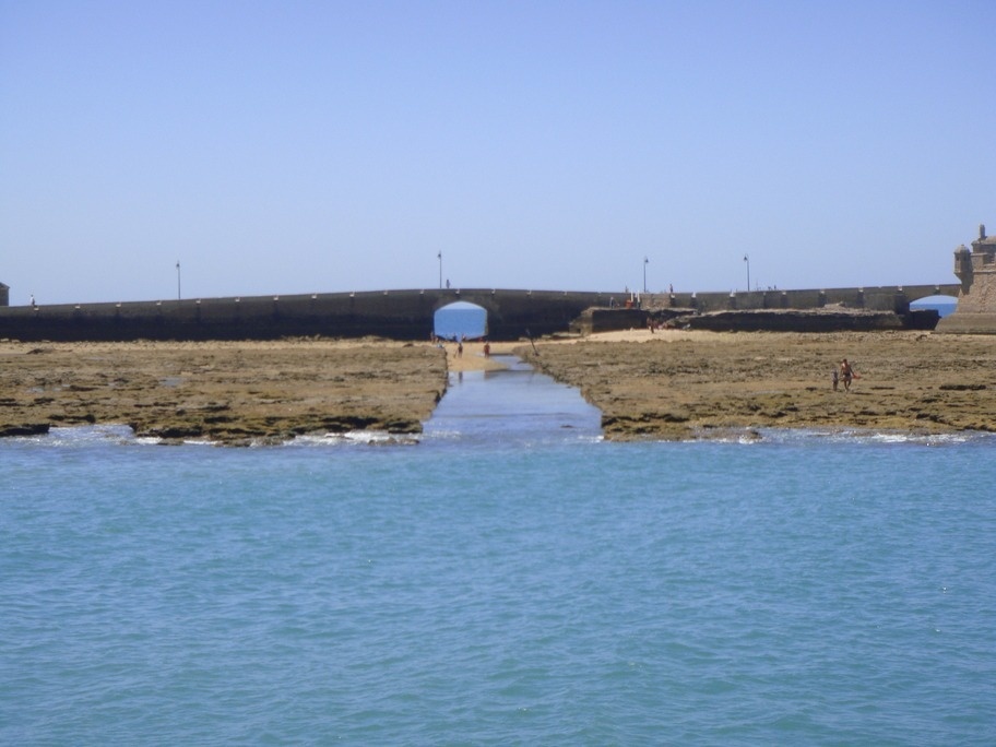 un puente que conduce a una playa en el océano