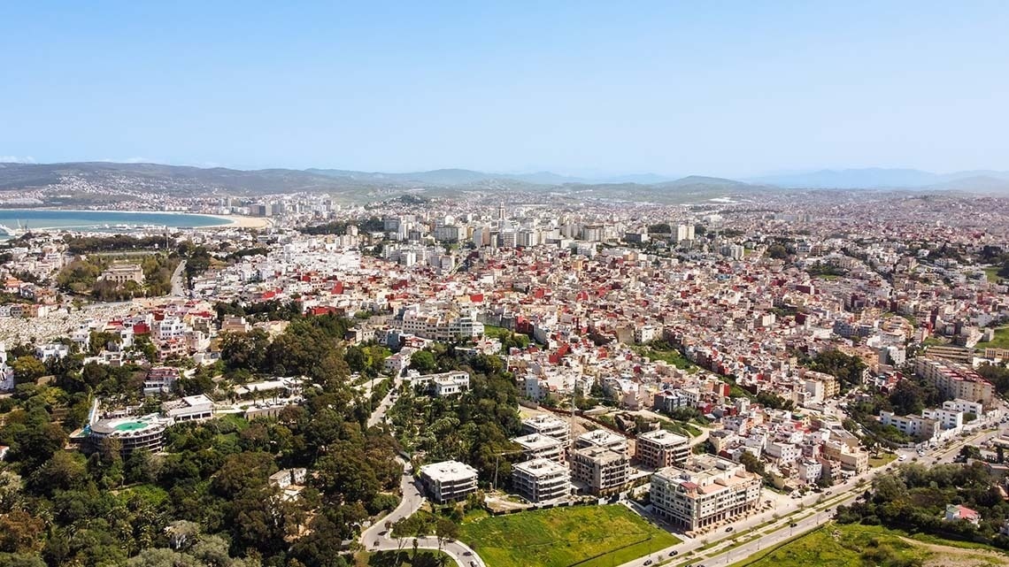 an aerial view of a city with mountains in the background