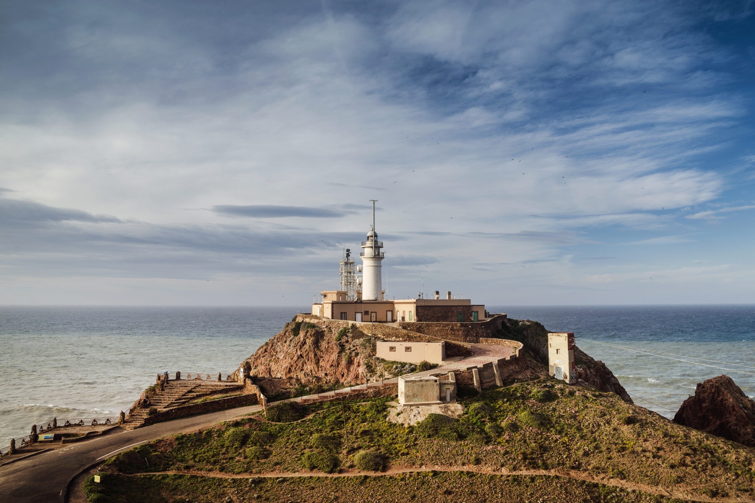 a lighthouse on top of a hill overlooking the ocean