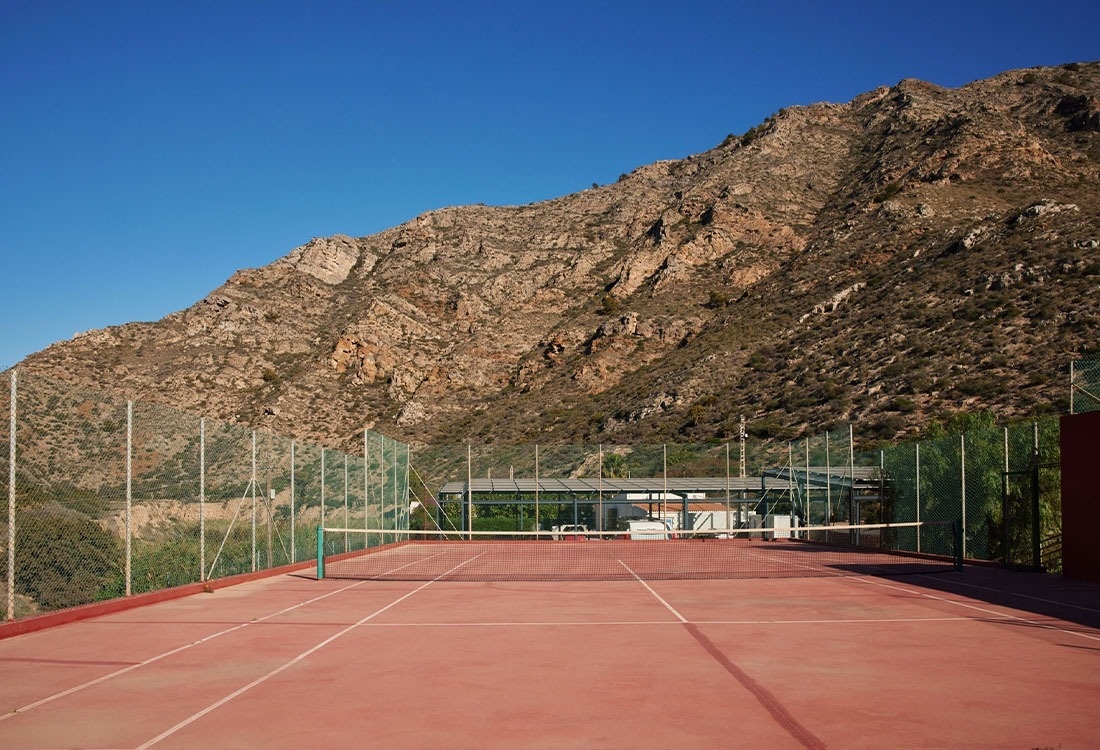 un homme marche sur un court de tennis tenant une raquette de tennis
