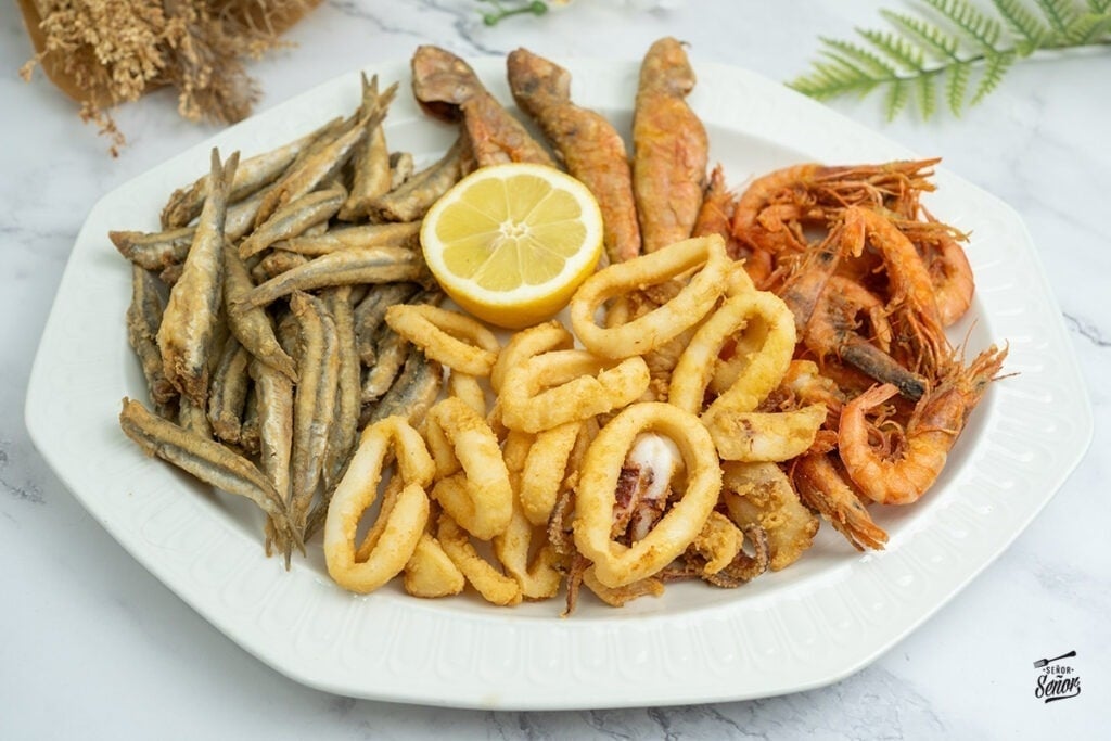 une assiette de fruits de mer frits avec une tranche de citron