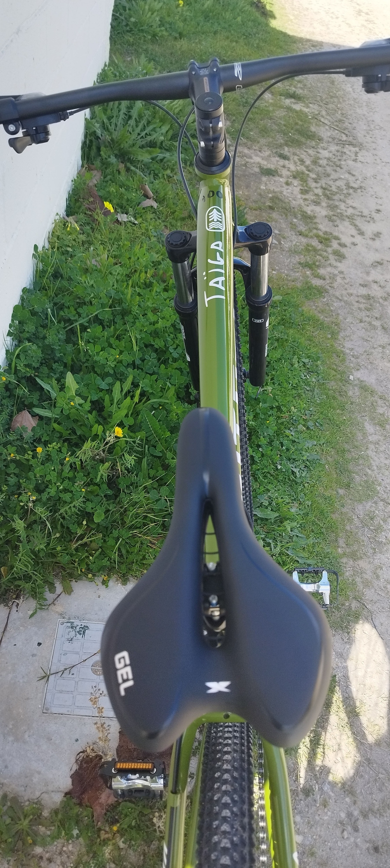 un vélo vert avec un siège gel assis sur un trottoir