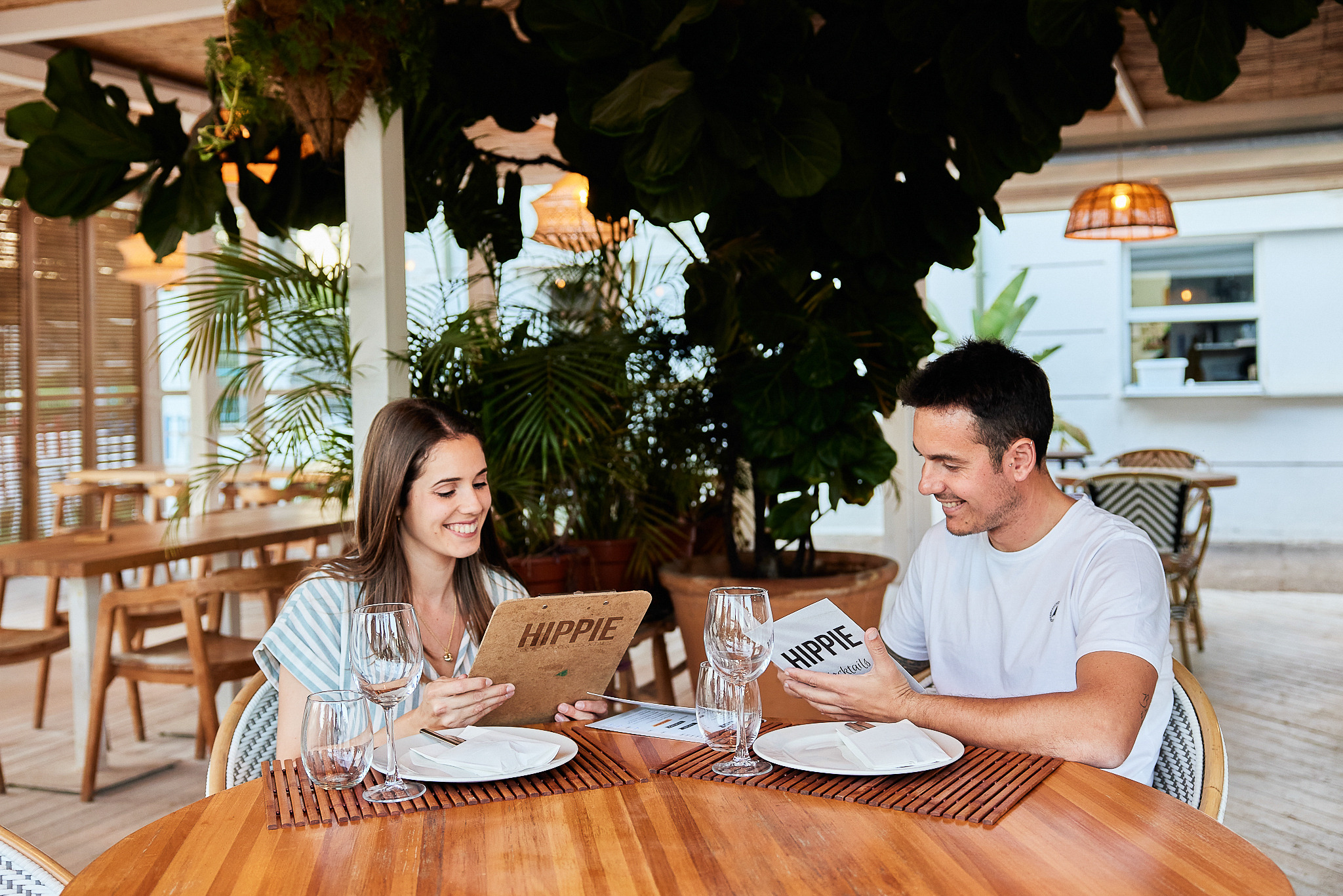 Pareja feliz en restaurante de hotel tropical, revisando menú Taiga: Corporativa.