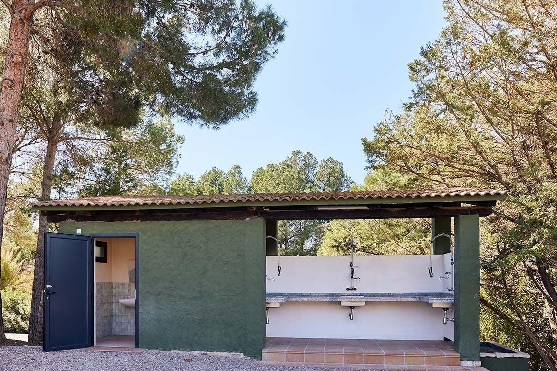 ein grünes Gebäude mit vielen Waschbecken davor