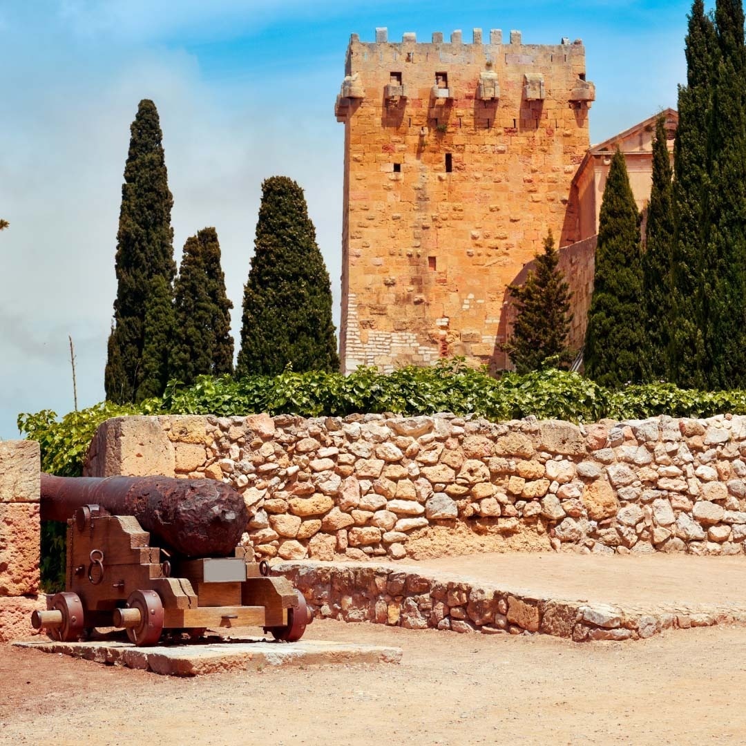 an old cannon sits in front of a stone wall