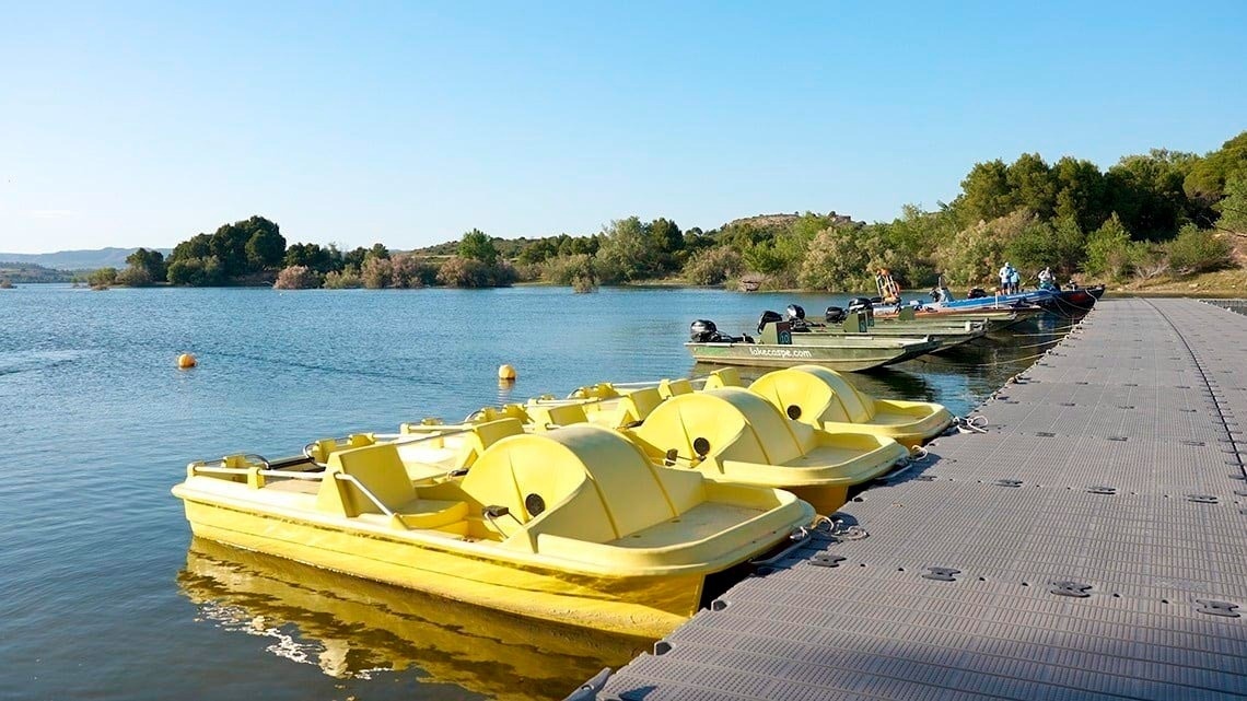 trois pédalo jaunes sont amarrés à un quai sur un lac