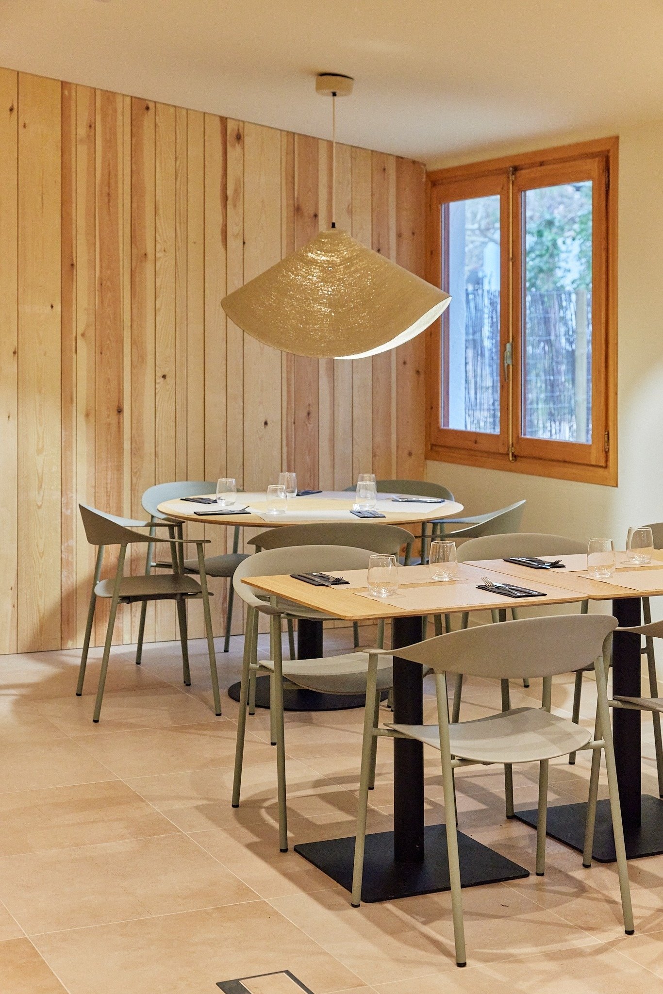 un comedor con mesas y sillas y una lámpara colgante