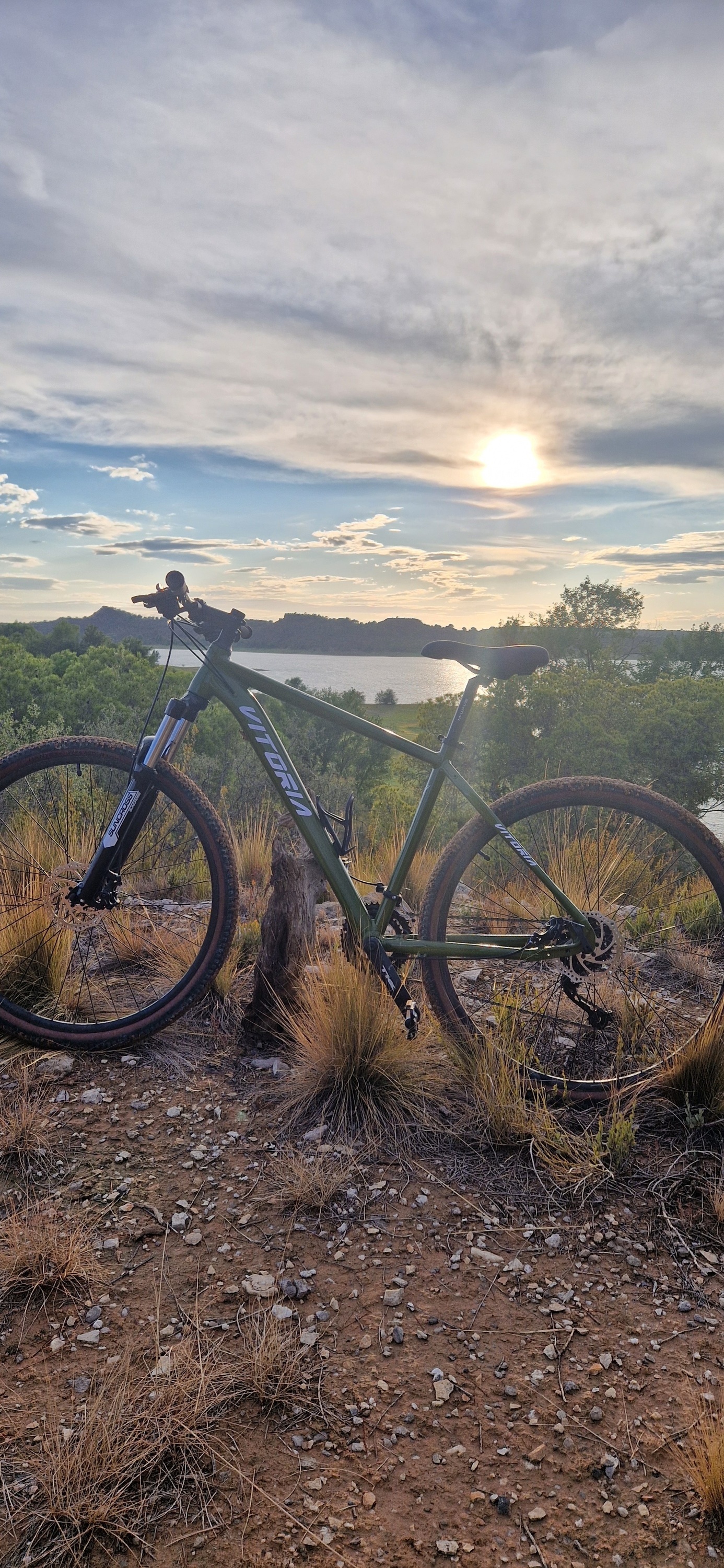 a green merida bike is parked on a dirt hill