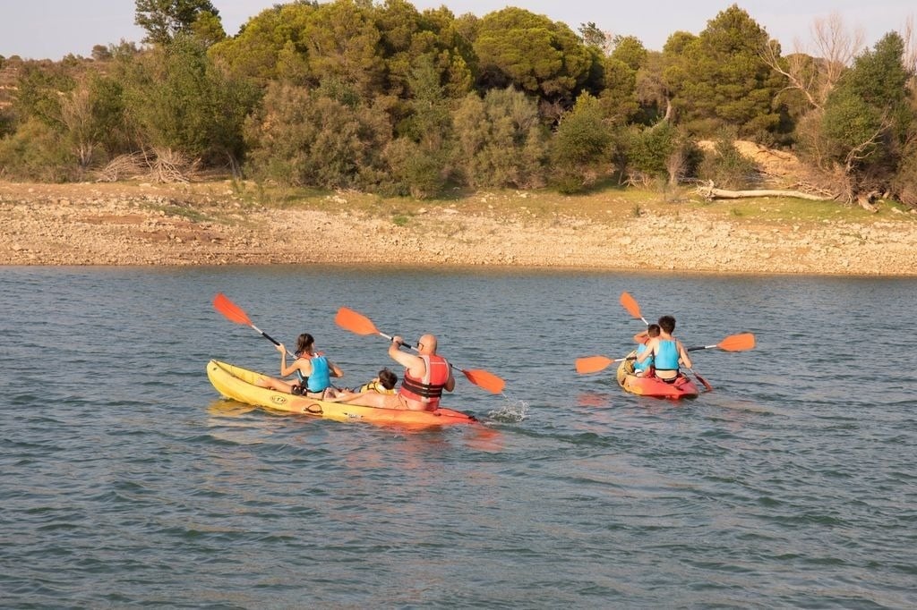un groupe de personnes pagaie sur un lac en kayak