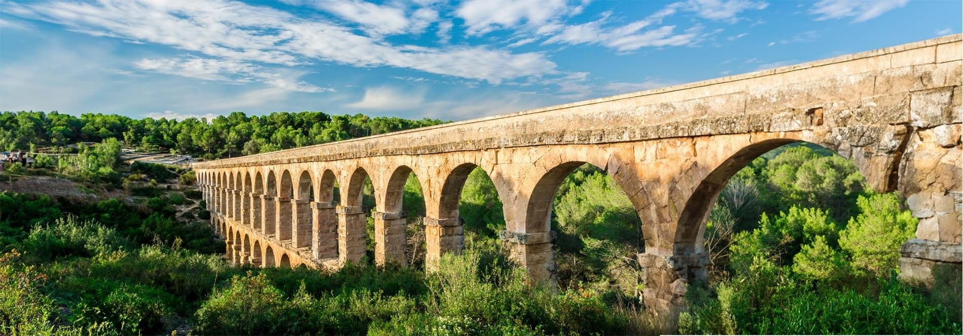 un río que atraviesa un campo verde con montañas en el fondo