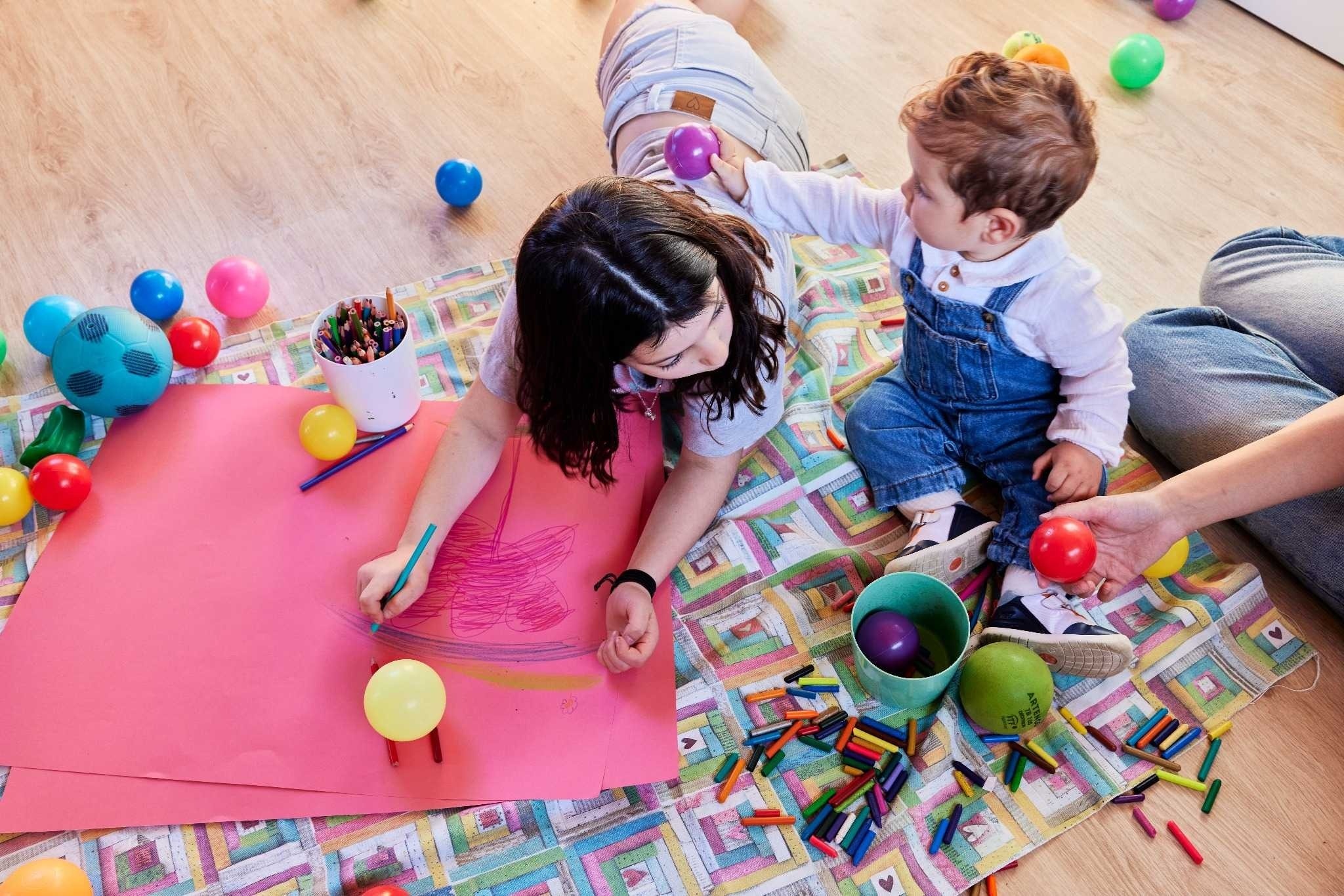 Niños jugando con pelotas y crayones en la alfombra Taiga: Corporativa.