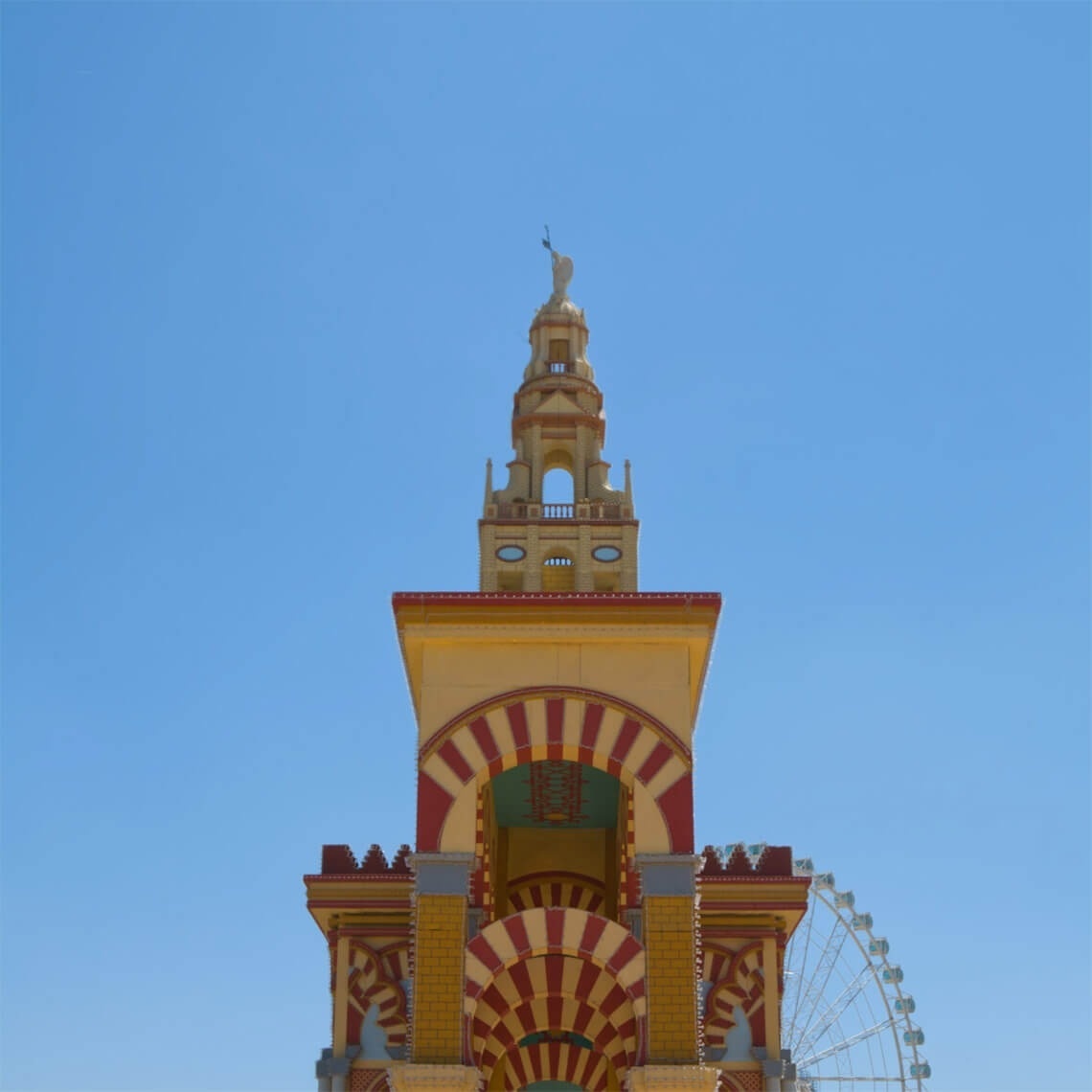ein Gebäude mit einem Turm und einem Riesenrad dahinter