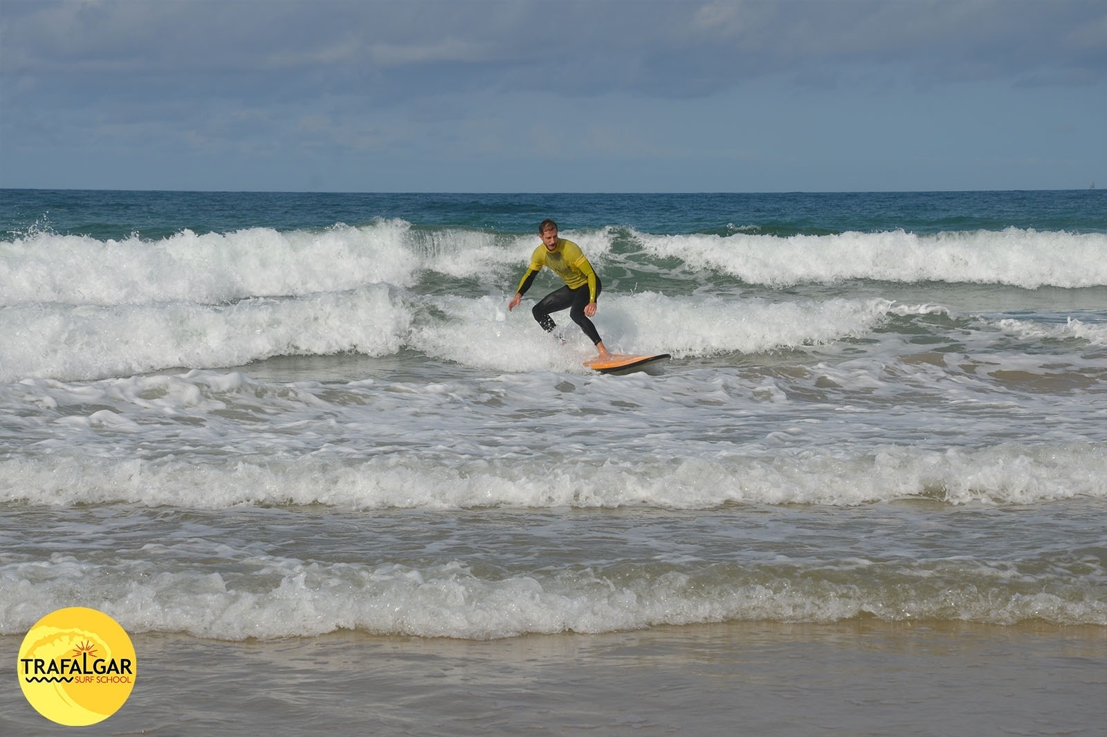 un surfista monta una ola en la playa de trafalgar