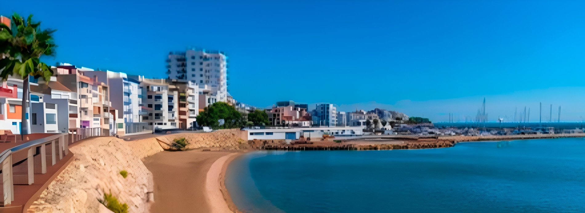 una playa con muchos edificios y barcos en el fondo